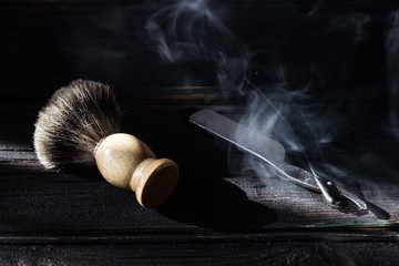 Straight razor and shaving brush on a luxury wooden background