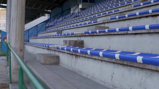 Bunch of blue bleachers recorded in slow motion at the city stadium.
