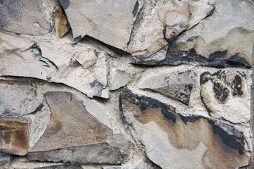 A fragment of a wall enclosed by large gray stones. Stony gray background