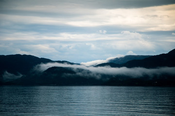 A dramatic, overcast scenery on the coeast of fjord during a ferry ride in Norway near Bergen....