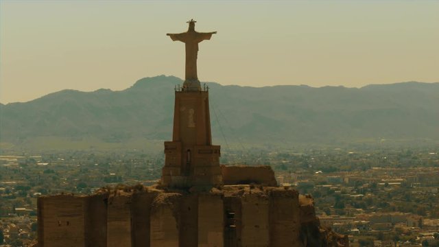 Aerial shot of statue of Chist on ancient Castillo de Monteagudo, Spain