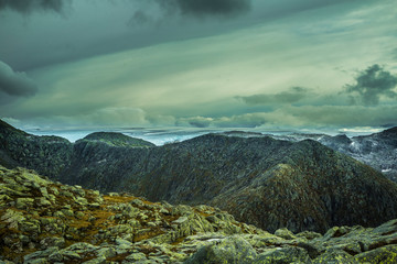 A mountain landscape with a Folgefonna glacier in the distance. A distant scenery of ice. Autumn in national park in Norway.