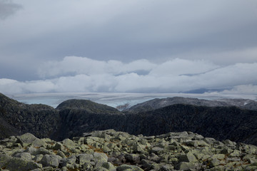 A mountain landscape with a Folgefonna glacier in the distance. A distant scenery of ice. Autumn in national park in Norway.