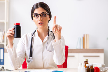 Woman doctor with bottle of medicines