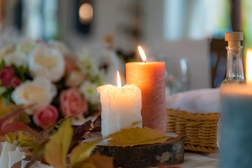 Autumn decoration setup on table in restaurant, with colorful tree leaves and candles