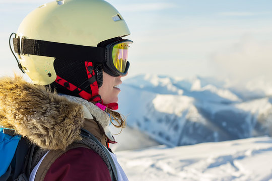 portrait of a snowboarder woman freerider in helmet in snowy mountains