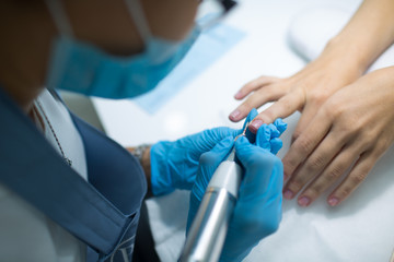 Woman in nail salon applying beauty manicure. Luxury woman hands.