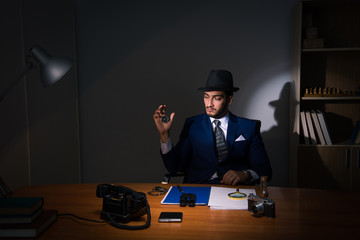 Detective sitting in dark room in vintage concept