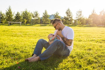 Happy father holding baby son on nature. Concept of happy family, father's day and child.