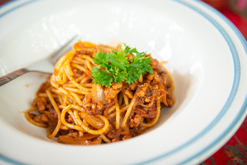 Top view of spaghetti with ketchup and pork chop on wooden table