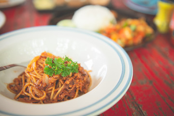 Top view of spaghetti with ketchup and pork chop on wooden table