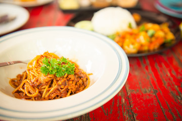 Top view of spaghetti with ketchup and pork chop on wooden table