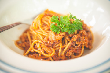Top view of spaghetti with ketchup and pork chop on wooden table