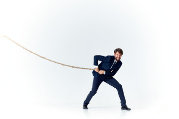 business man pulls the rope on a light background