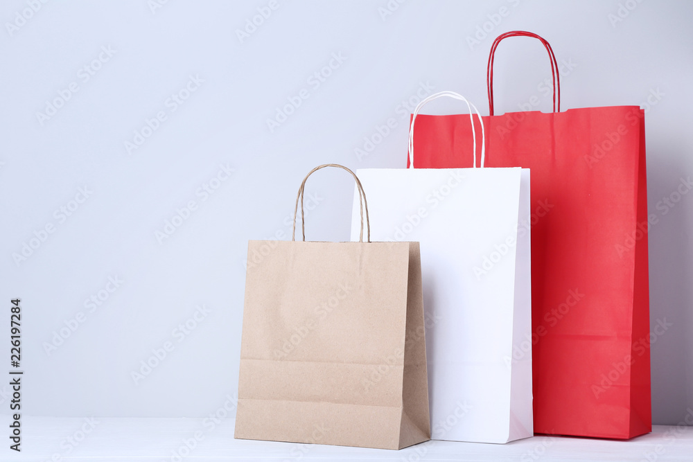 Poster Colorful paper shopping bags on grey background