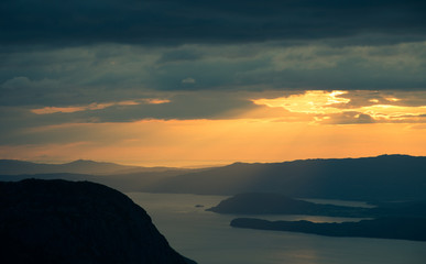 A magnificent sunset scenery over the fjords in Norway. A beautiful autumn landscape in Folgefonna national park. Dramatic sky and mountains.