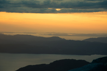A magnificent sunset scenery over the fjords in Norway. A beautiful autumn landscape in Folgefonna national park. Dramatic sky and mountains.