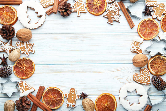 Christmas gingerbread cookies with dry oranges and walnuts on white wooden table