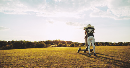 American football player doing tackling drills on a sports field