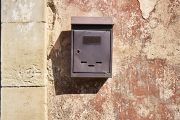 Cassetta della posta sul  vecchio intonaco di una casa abbandonata