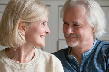 Smiling loving mature senior man and woman looking at each other enjoying true sincere feelings and good relations in marriage, happy middle aged romantic affectionate family couple dating concept