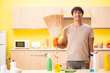 Single man cleaning kitchen at home