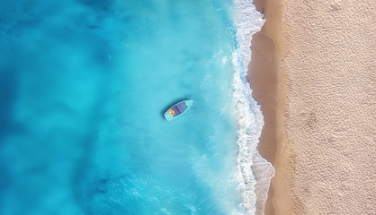 Fototapeta na wymiar Boat on the water surface from top view. Turquoise water background from top view. Summer seascape from air. Travel concept and idea
