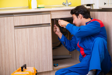 Plumber repairing  wash basin at kitchen