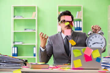 Businessman unhappy with many conflicting priorities sitting in 