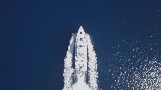 Following a Large speedboat roaring across the Mediterranean Sea - Top down aerial footage.