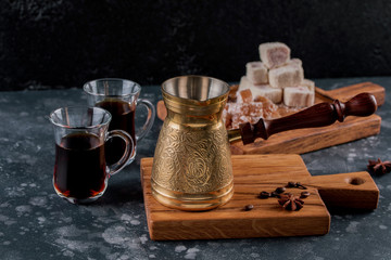 Hot turkish coffee pot on wooden board. Aroma drink beverage turkish coffee into traditional embossed metal turk.