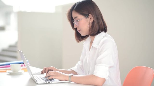 Young Asian woman working with laptop in the moden office