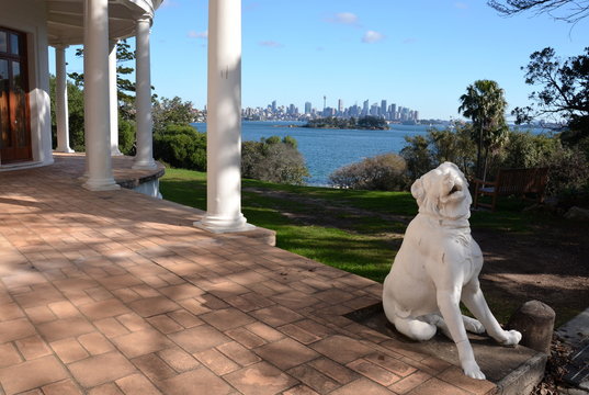Sydney, Australia - Jun 20, 2015. Dog sculpture at Strickland House. View of Sydney skyline and Sydney Harbour in the background.