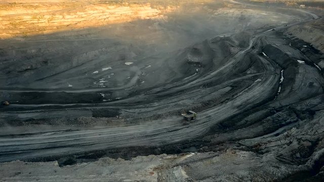 Aerial quarry shot from drone. Industrial vehicles. Opencast mining concept.