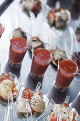 Salmon and crustaceans on spoons and tomato juice