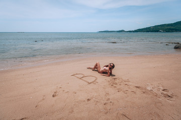 Image of icon bitcoin on golden sand, near sit happy bitcoin girl . Concept freelance, stock exchange