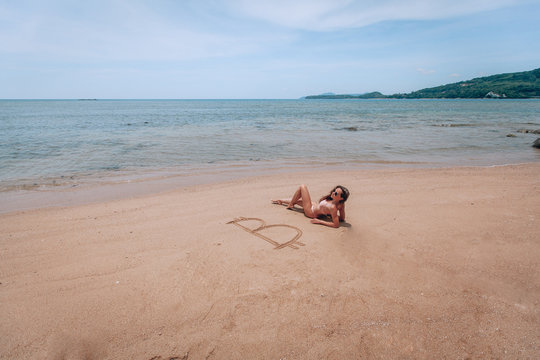Image of icon bitcoin on golden sand, near sit happy bitcoin girl . Concept freelance, stock exchange