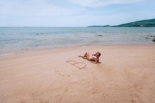 Image of icon bitcoin on golden sand, near sit happy bitcoin girl . Concept freelance, stock exchange