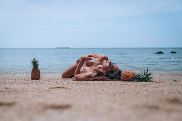 Fun retro beach fashion concept. Woman in pineapple bathing suit at the beach