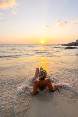 Beautiful young woman on a sandy ocean beach in a swimsuit