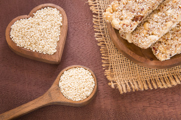 Seeds of organic sesame and cereal bar - Sesamum indicum. Wood background