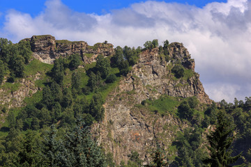 Fototapeta na wymiar Stone ledge of a rocky ridge against the blue sky. Caucasian mountain range in Russia.