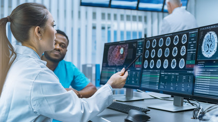 Medical Scientist and Surgeon Discussing CT Brain Scan Images on a Personal Computer in Laboratory....