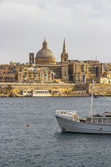 Fototapeta na wymiar Valletta skyline as seen from Sliema, with a part of a boat in the foreground, at Valletta, Malta