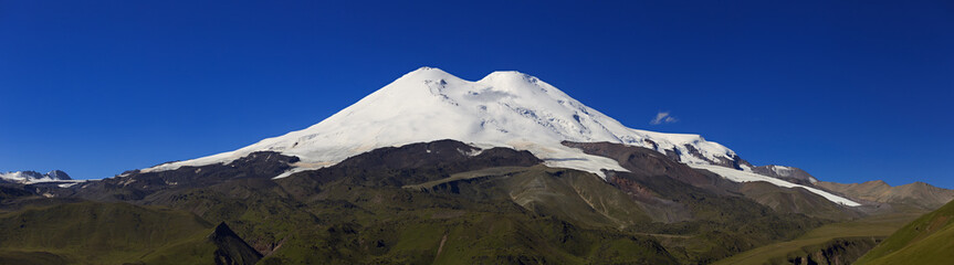 Panoramic view of the northern slope of Mount Elbrus of the Caucasus Mountains in Russia. Snow-covered peaks of the stratovolcano.