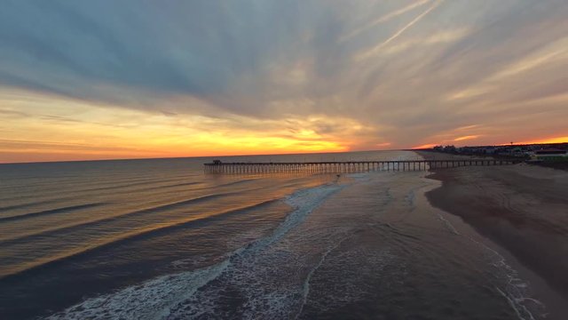 Aerial Footage of a Golden Sunset at the Pier in Emerald Isle, NC - A Flyby with Relaxing Waves