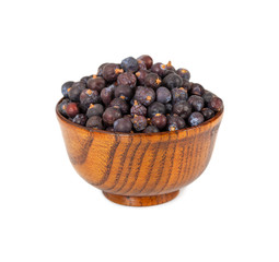 Dried juniper berries in wooden bowl isolated on white