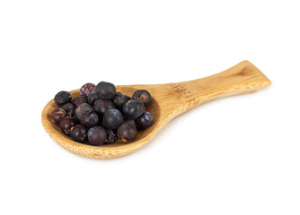 Dried juniper berries in wooden spoon isolated on white
