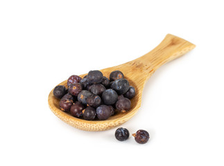 Dried juniper berries in wooden spoon isolated on white