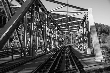 Steel railroad bridge close up on a bright autumn day in black and white.